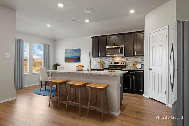 a kitchen with stainless steel appliances granite countertop a stove a sink and a refrigerator