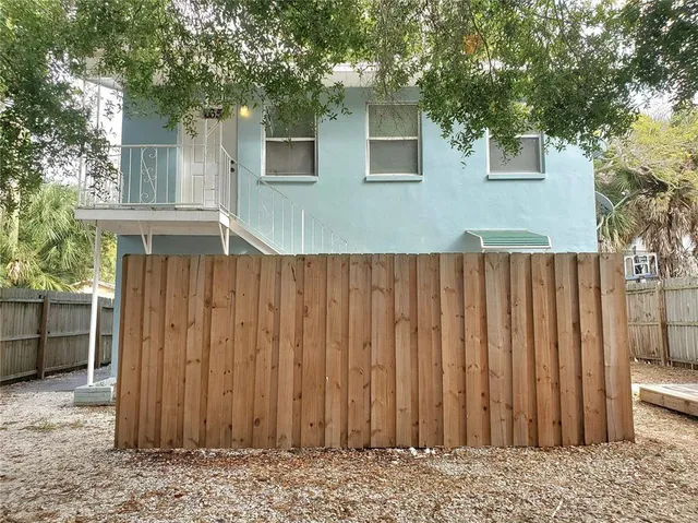 a view of a house with wooden fence