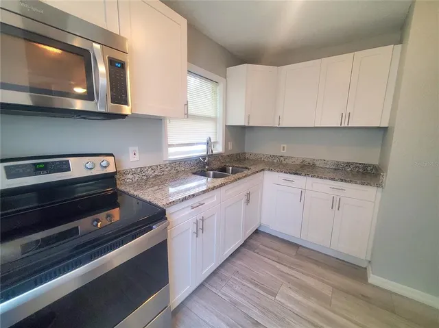 a kitchen with stainless steel appliances granite countertop a stove and a microwave