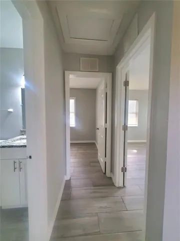 a view of a hallway with wooden floor and closet