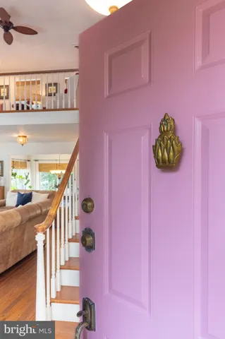 a kitchen with stainless steel appliances granite countertop a refrigerator a sink dishwasher a stove and a dining table with wooden floor