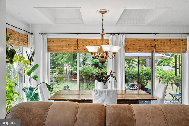 a view of a patio with table and chairs potted plants and large tree