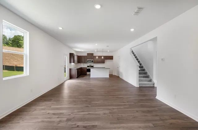 a view of a kitchen with furniture and wooden floor