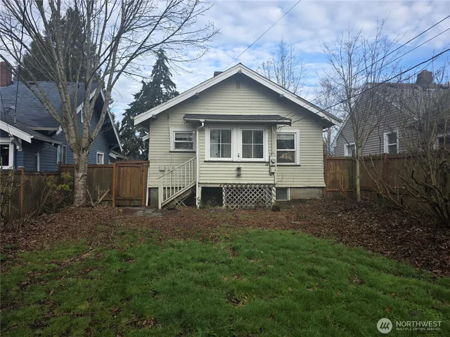 a view of a house with a yard and large trees
