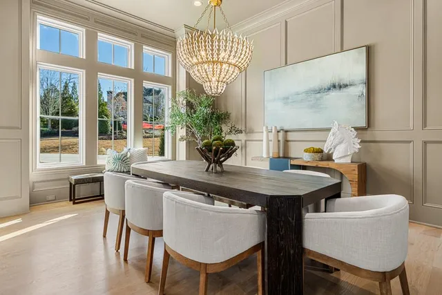 an empty room with wooden floor chandelier and windows