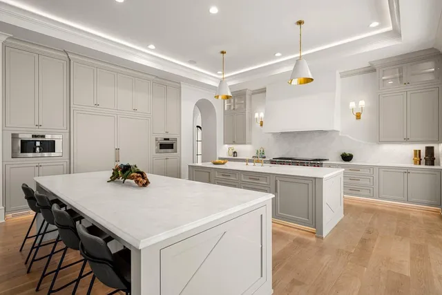 a large kitchen with stainless steel appliances granite countertop a large counter top and wooden floor