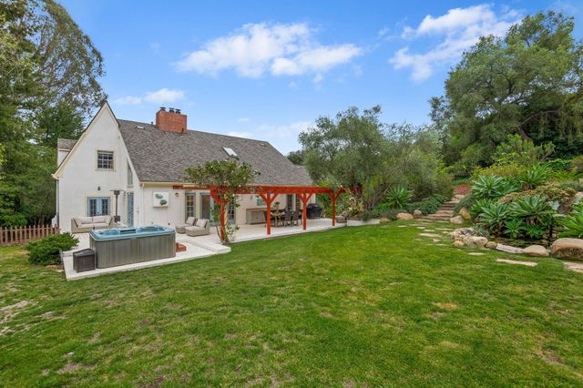 a view of a house with a big yard and large trees