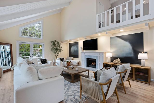 a living room with furniture a fireplace and a flat screen tv