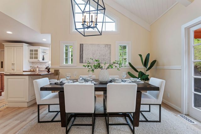 a dining room with furniture a potted plant and a chandelier