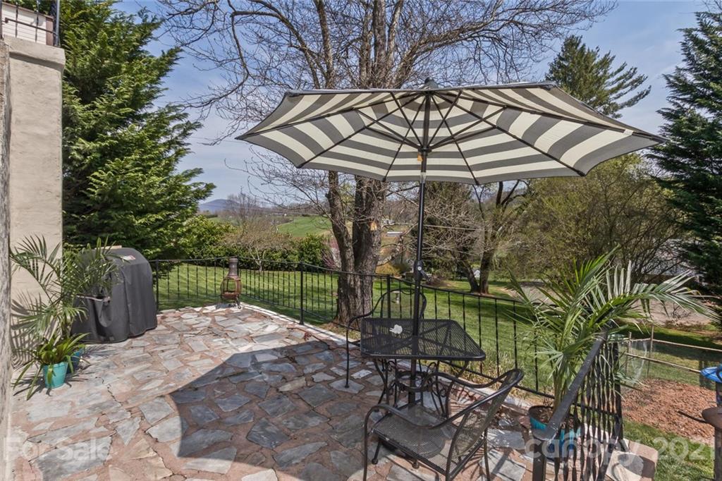 127 Queentown Road Canton, NC 28716 - Photo 29 of 43 a view of a patio with a table and chairs under an umbrella