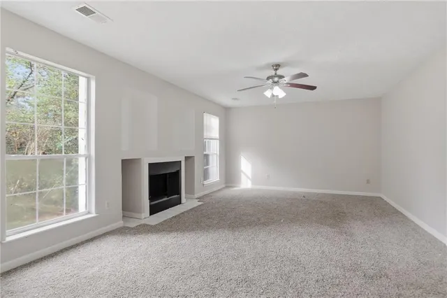an empty room with windows and fireplace