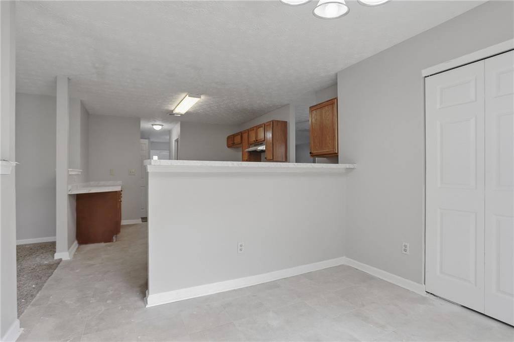 2191 Phillips Road Lithonia, GA 30058 - Photo 14 of 41 an empty room with kitchen view and wooden floor