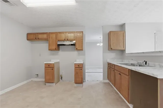 a kitchen with a sink and a stove top oven
