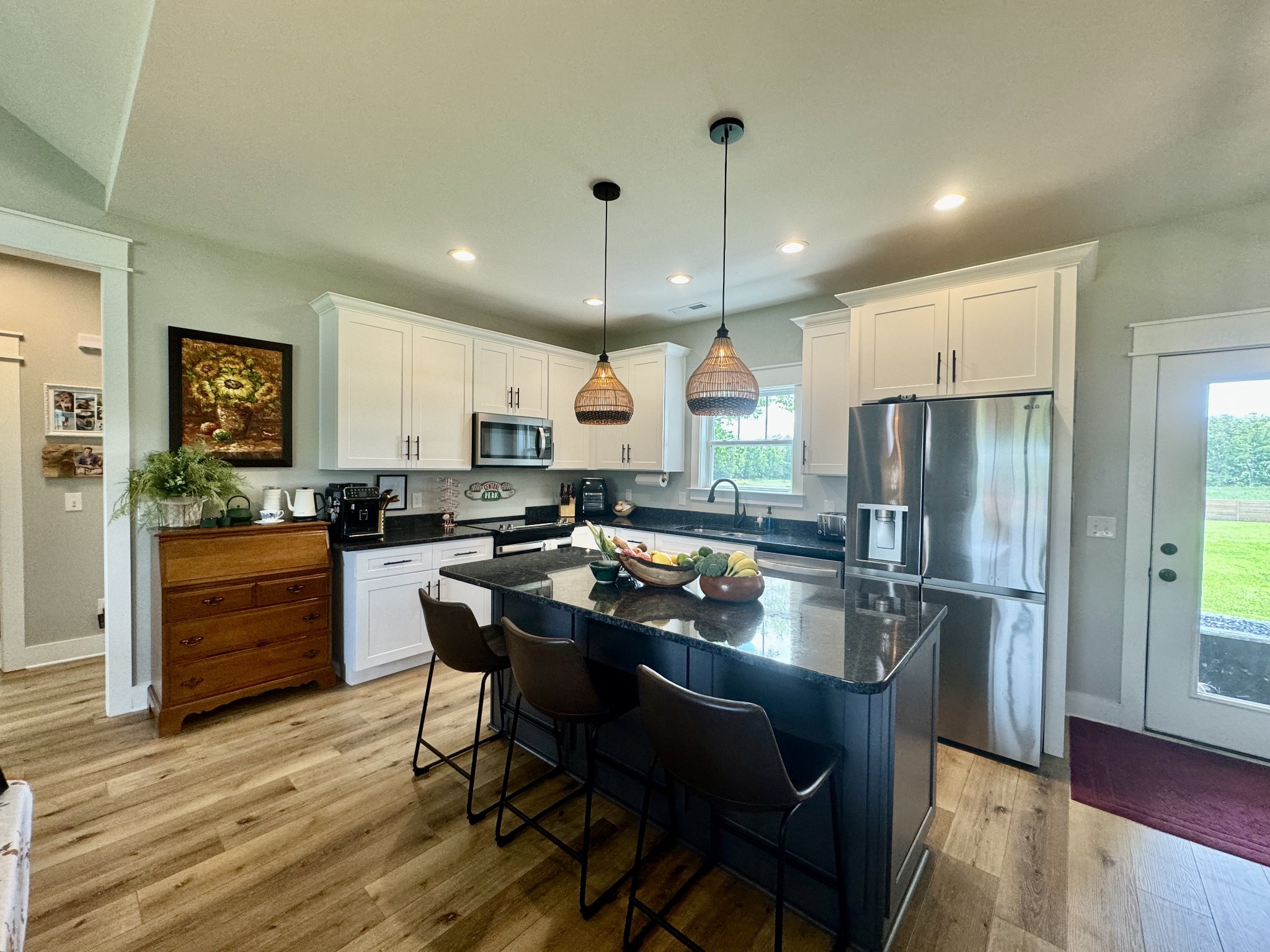 172 Tenpenny Road Morrison, TN 37357 - Photo 4 of 27 a kitchen with kitchen island granite countertop a refrigerator a stove a sink a dining table and chairs with wooden floor