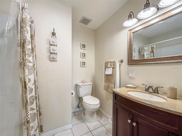 a bathroom with a granite countertop sink a toilet and a mirror