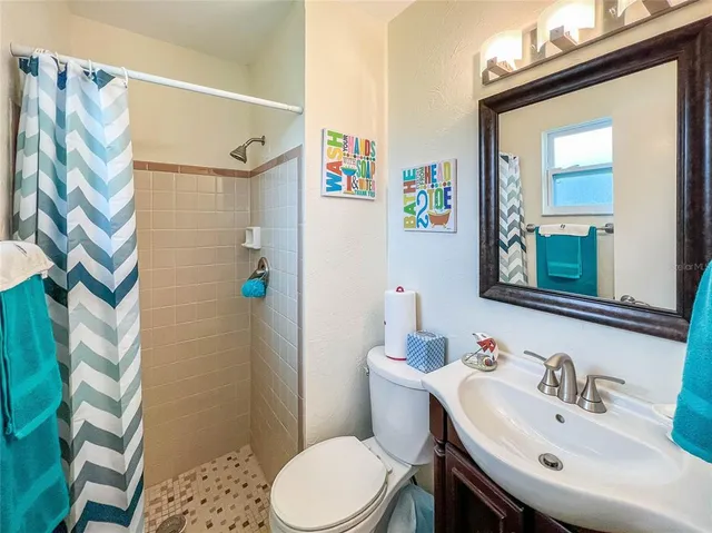 a bathroom with a sink a toilet and shower curtain
