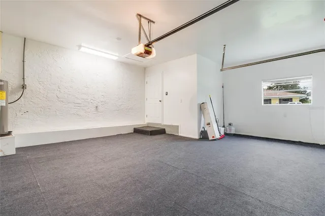 an empty room with chandelier fan and windows