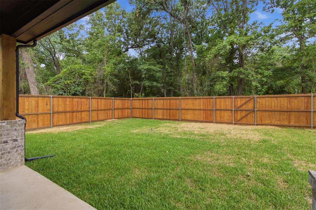 429 Waterboard Road Trinidad, TX 75163 - Photo 20 of 25 Expansive backyard featuring a wood fence, a patch of green grass, and mature trees beyond the fence line