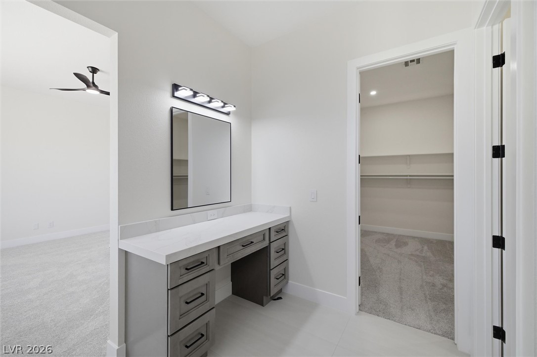 5910 East Kellogg Road Pahrump, NV 89061 - Photo 35 of 58 A well-appointed dressing area featuring a vanity with ample storage and overhead lighting.