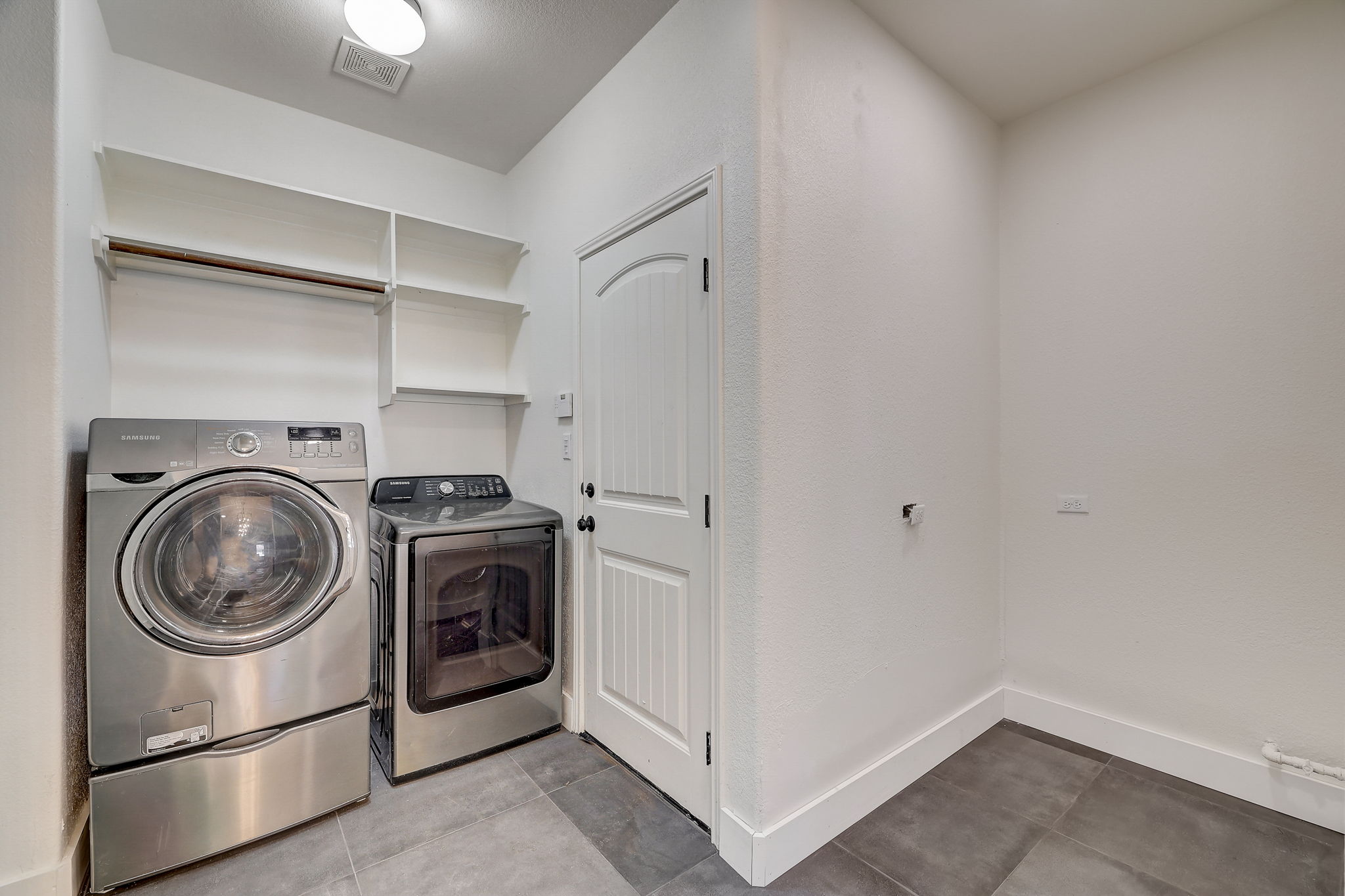 16012 Spillman Ranch Loop Austin, TX 78738 - Photo 20 of 38 A dedicated laundry room with convenient shelving and contemporary washer and dryer units.