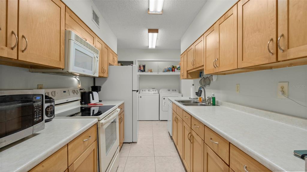 6519 West Newberry Road, Unit 912 Gainesville, FL 32605 - Photo 18 of 47 a kitchen with a sink a stove and cabinets