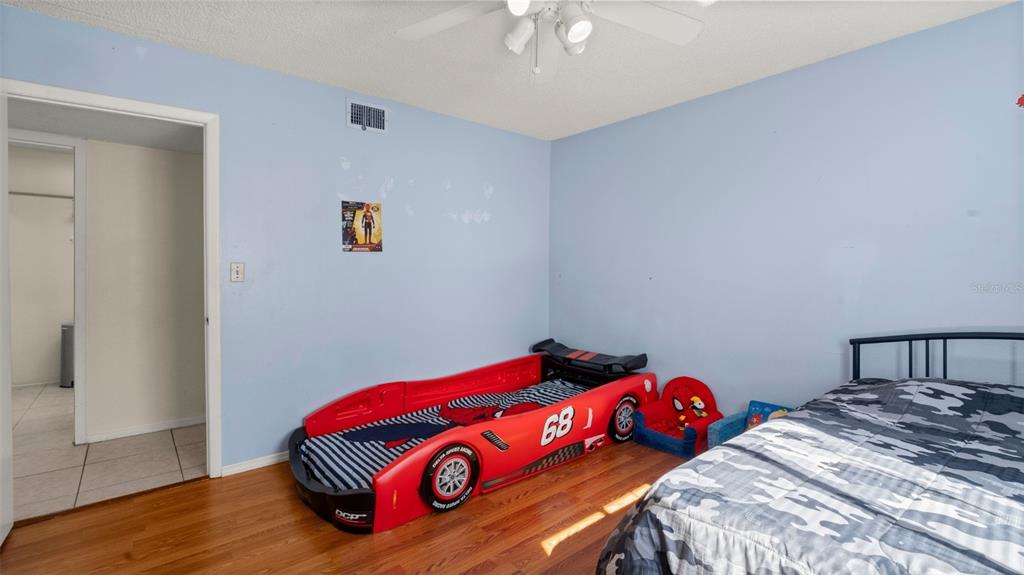 6519 West Newberry Road, Unit 912 Gainesville, FL 32605 - Photo 26 of 47 a bedroom with a bed and a chandelier