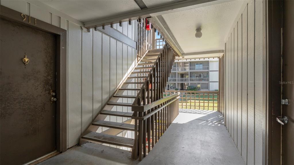 6519 West Newberry Road, Unit 912 Gainesville, FL 32605 - Photo 7 of 47 a view of staircase with wooden floor and white walls