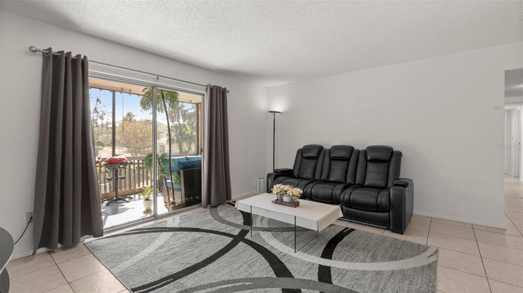6519 West Newberry Road, Unit 912 Gainesville, FL 32605 - Photo 10 of 47 a living room with furniture and a floor to ceiling window