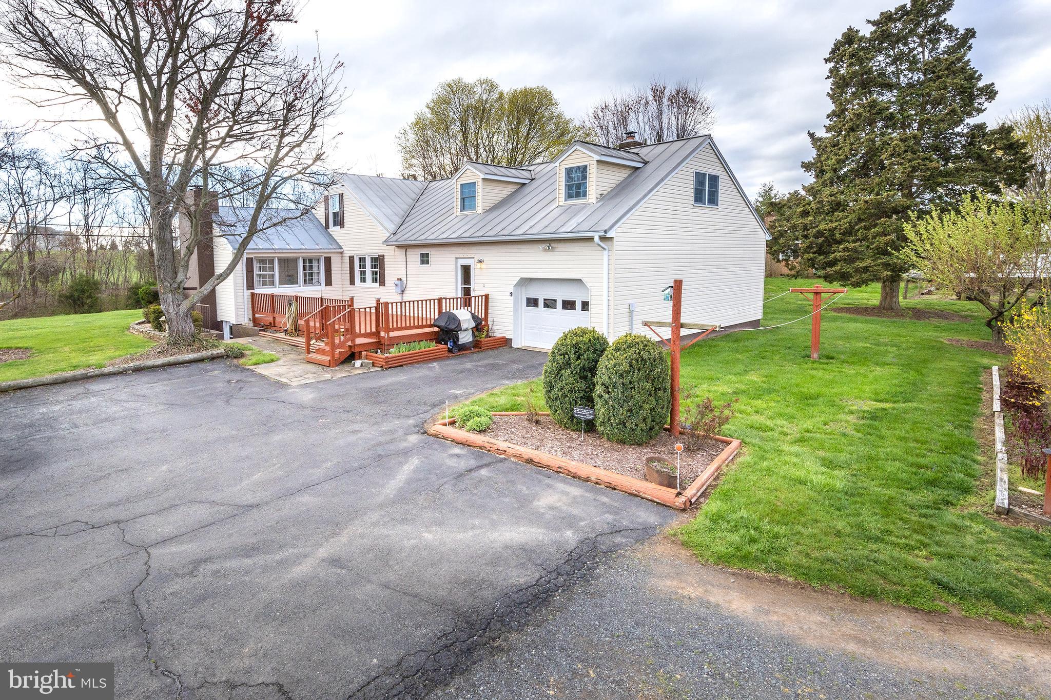 23045 Watson Road Leesburg, VA 20175 - Photo 4 of 69 a view of a white house next to a yard with big trees and plants