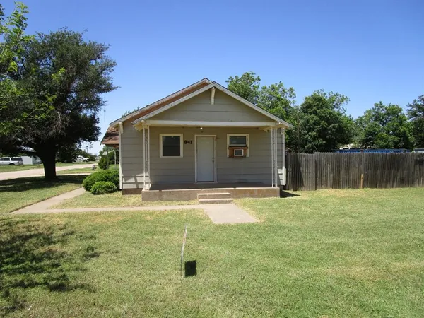 a backyard of a house with table and chairs
