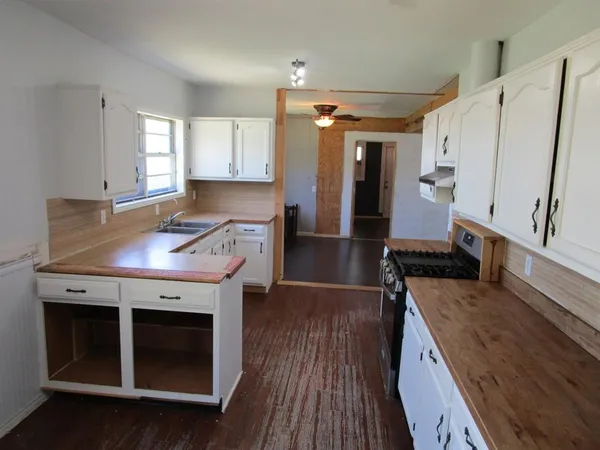 a kitchen with white cabinets and appliances