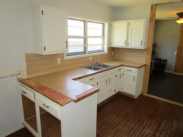 a kitchen with a refrigerator and wooden floor