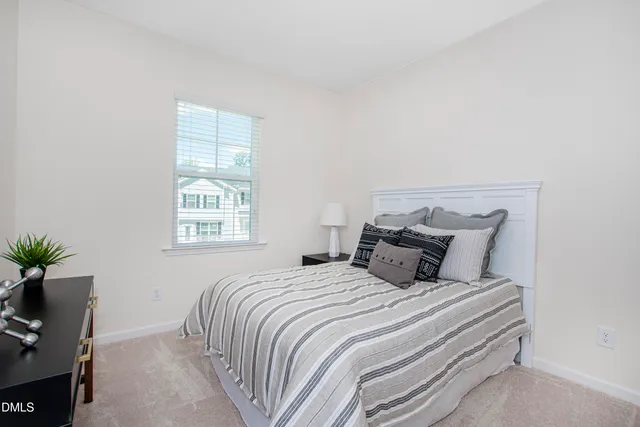 a bedroom with a large bed and a potted plant