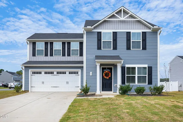 a front view of a house with a yard and garage
