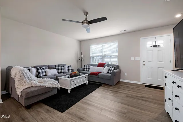 a living room with furniture and a wooden floor