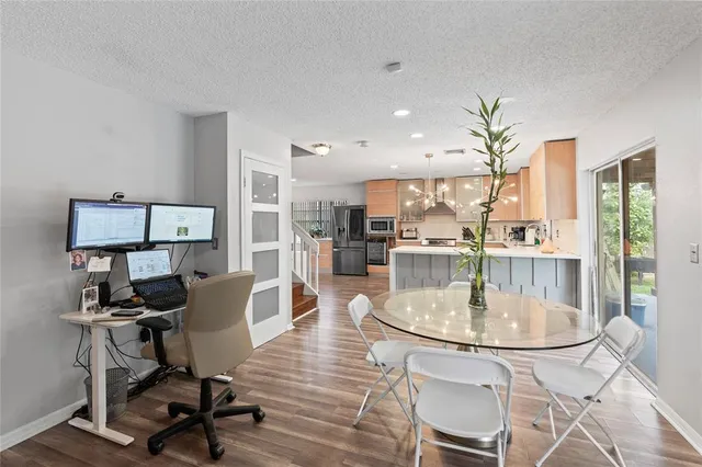 a dining room with wooden floor a glass table and chairs