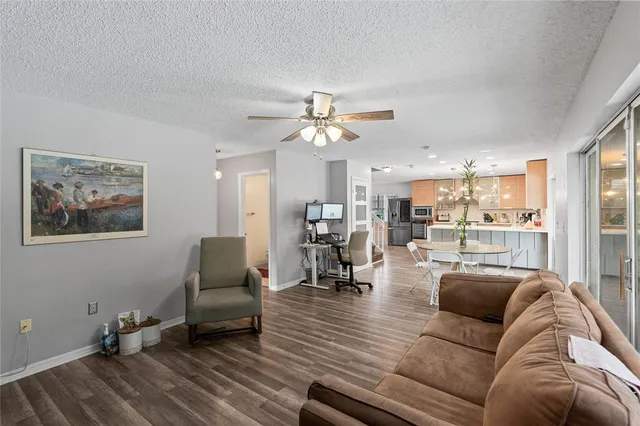 a living room with furniture and view of kitchen