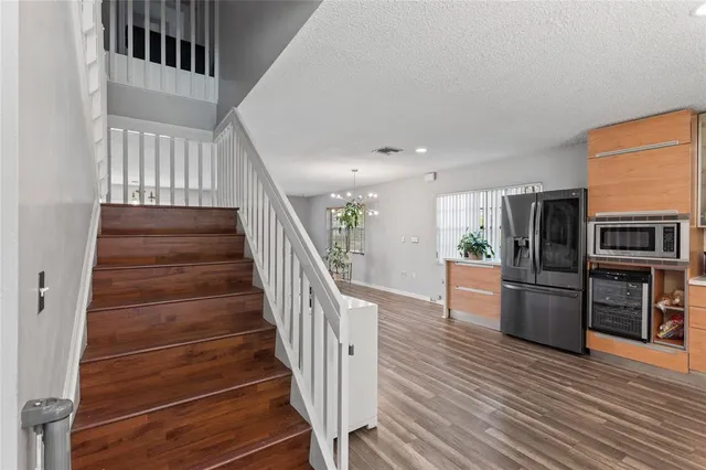 a view of entryway and kitchen with wooden floor