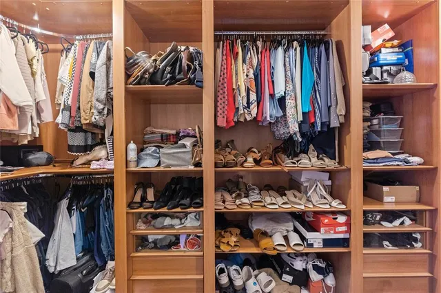 a view of walk in closet with clothes and shoes