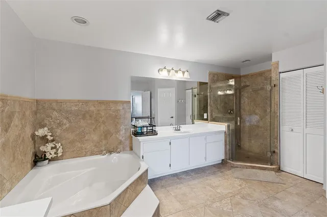 a large bathroom with a tub sink shower and mirror