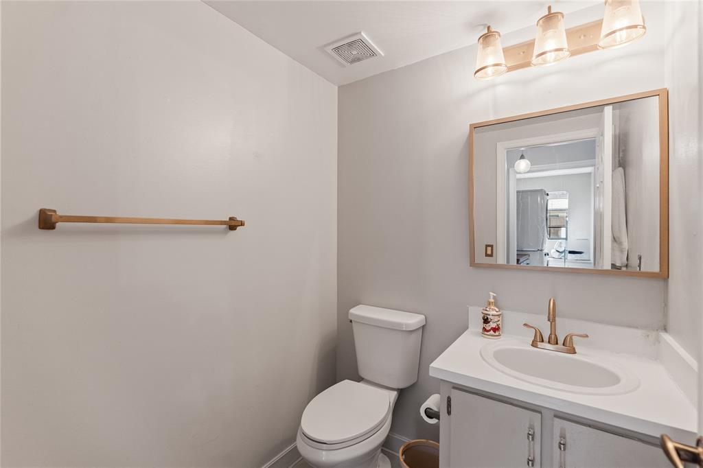520 Sumter Avenue Davie, FL 33325 - Photo 36 of 44 a bathroom with a toilet a sink a mirror and vanity