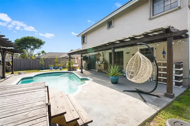 a view of a backyard with swimming pool table and chairs