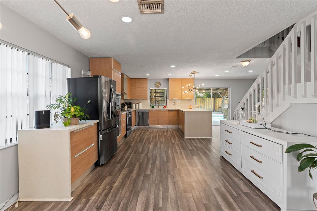 520 Sumter Avenue Davie, FL 33325 - Photo 6 of 44 a kitchen with cabinets wooden floor and stainless steel appliances