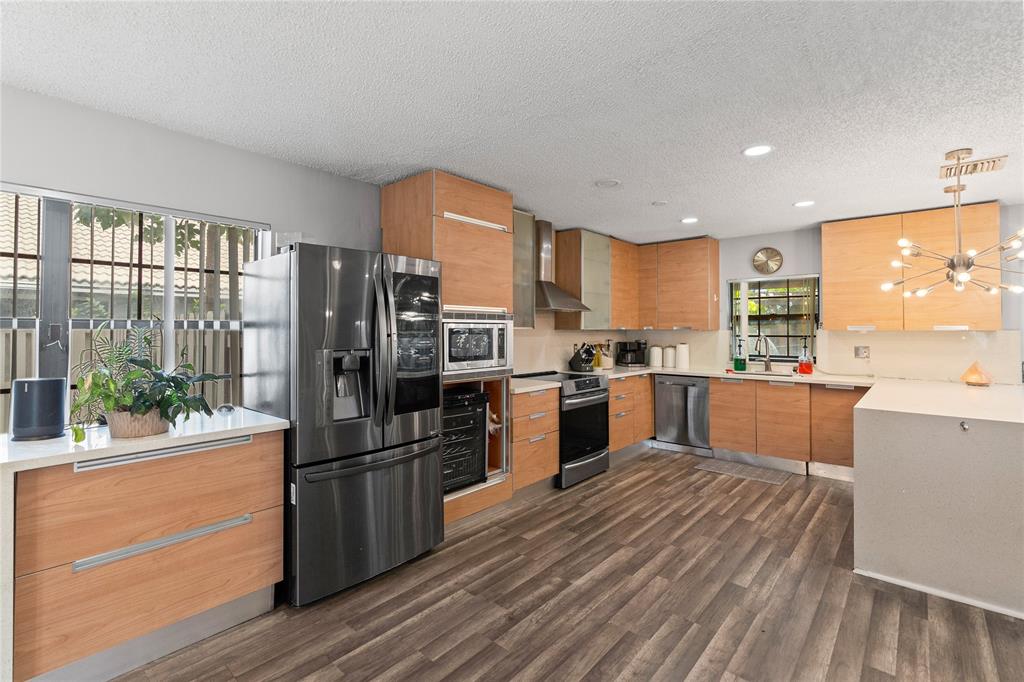 520 Sumter Avenue Davie, FL 33325 - Photo 7 of 44 a kitchen with granite countertop a refrigerator oven a sink dishwasher and wooden cabinets with wooden floor