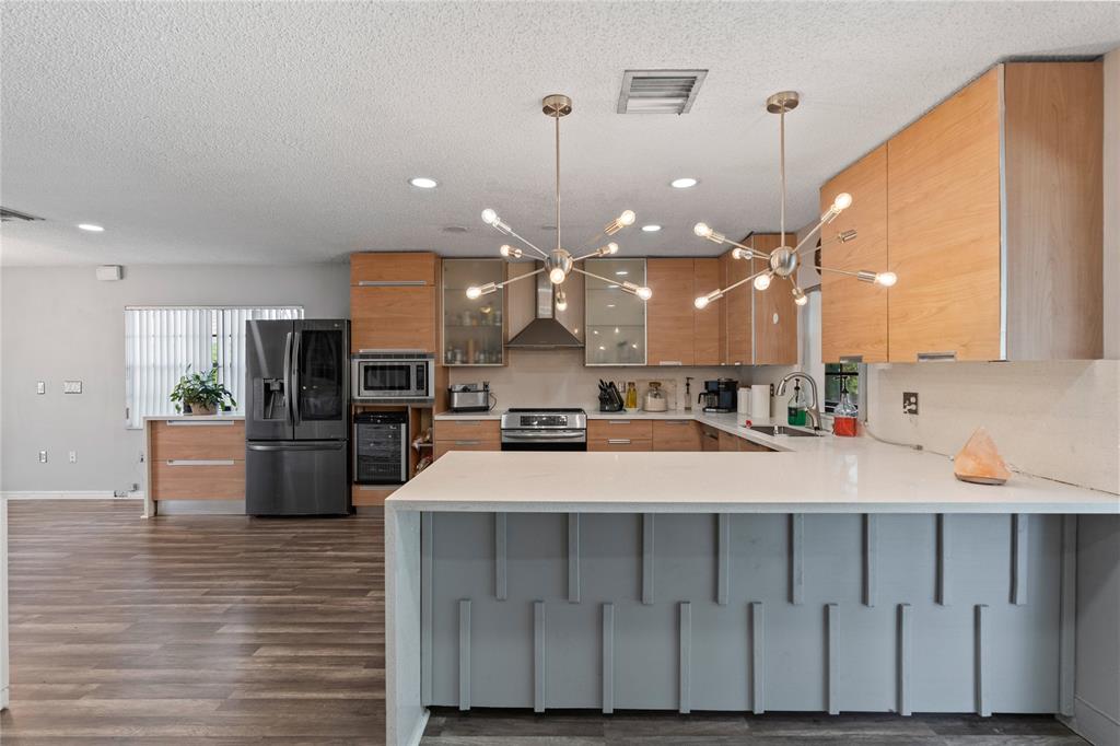 520 Sumter Avenue Davie, FL 33325 - Photo 8 of 44 a large white kitchen with a large island oven a stove and a refrigerator