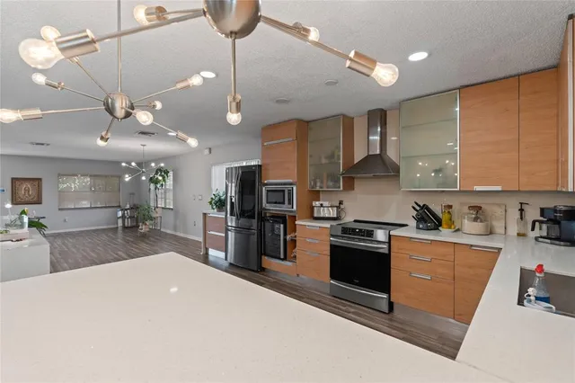 a large kitchen with kitchen island a large counter top space a sink stainless steel appliances and cabinets