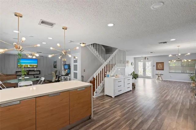 a room with lots of white furniture and wooden floor