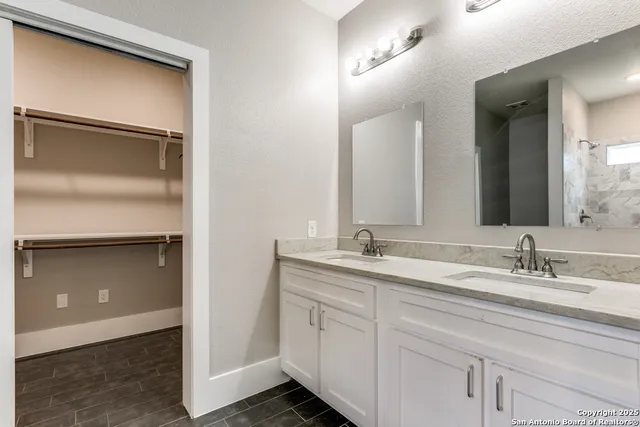 a bathroom with a double vanity sink and mirror
