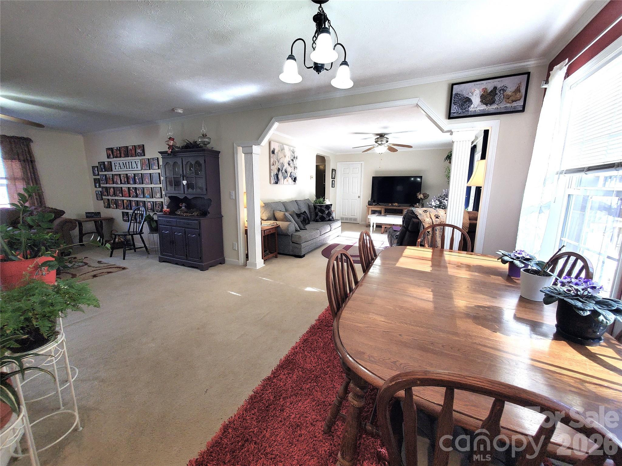 457 Dale Road Spruce Pine, NC 28777 - Photo 12 of 36 a dining room with wooden floor a chandelier a wooden table and chairs