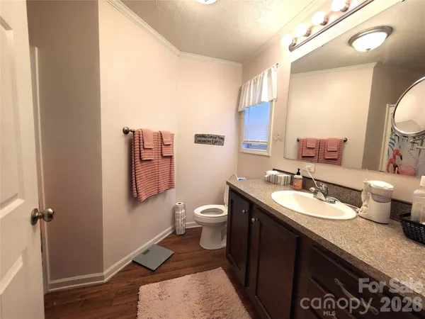 a bathroom with a granite countertop toilet sink and mirror